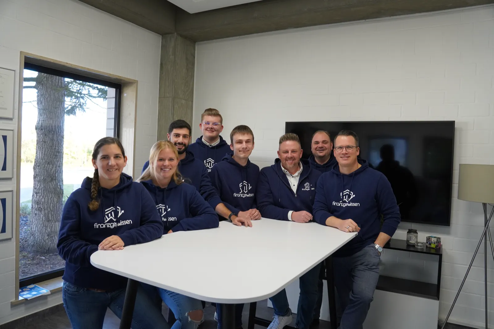 Das Team von Finanzgewissen aus Ahlen — Beraterinnen und Berater in Finanzgewissen-Hoodies gemeinsam im Büro